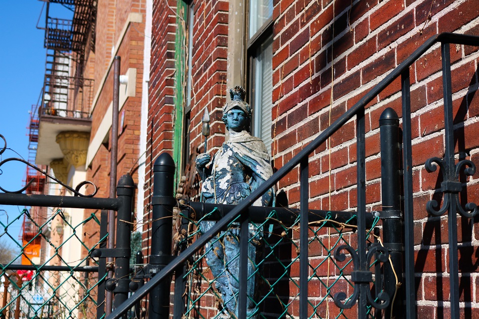 Blue Warrior statue infront of black fence